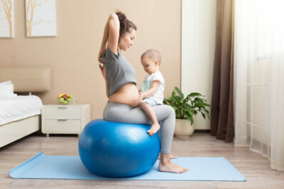 beautiful-pregnant-asian-woman-doing-fitness-exercise-with-toddler