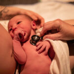 Midwife-checking-the-health-of-a-newborn-baby-moments-after-birth