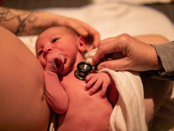 Midwife-checking-the-health-of-a-newborn-baby-moments-after-birth