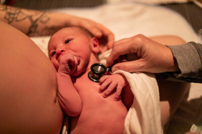 Midwife-checking-the-health-of-a-newborn-baby-moments-after-birth