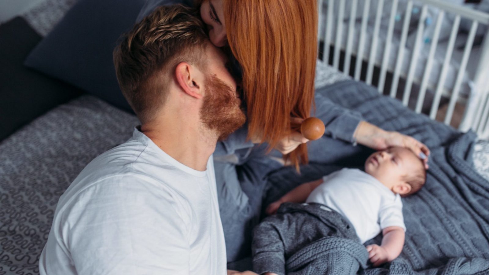 Young parents sitting on a bed. Sex after baby