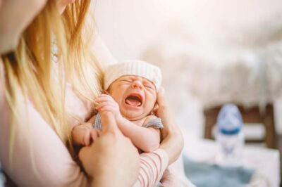 Young mom with crying newborn baby