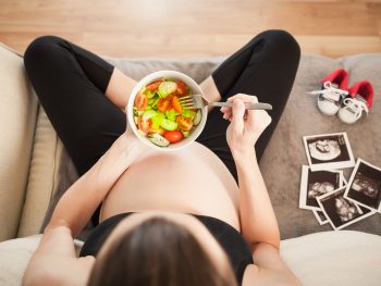 Pregnant woman eating a salad to have a good microbiome