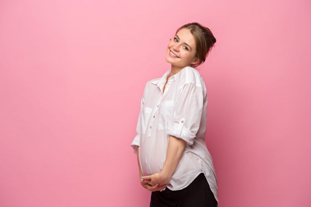 Pregnant woman against pink background