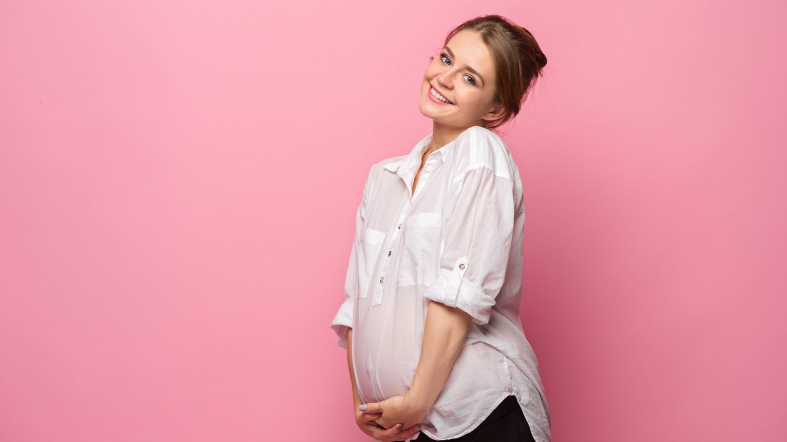 Pregnant woman against pink background