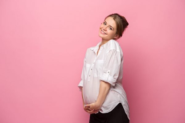 Pregnant woman against pink background