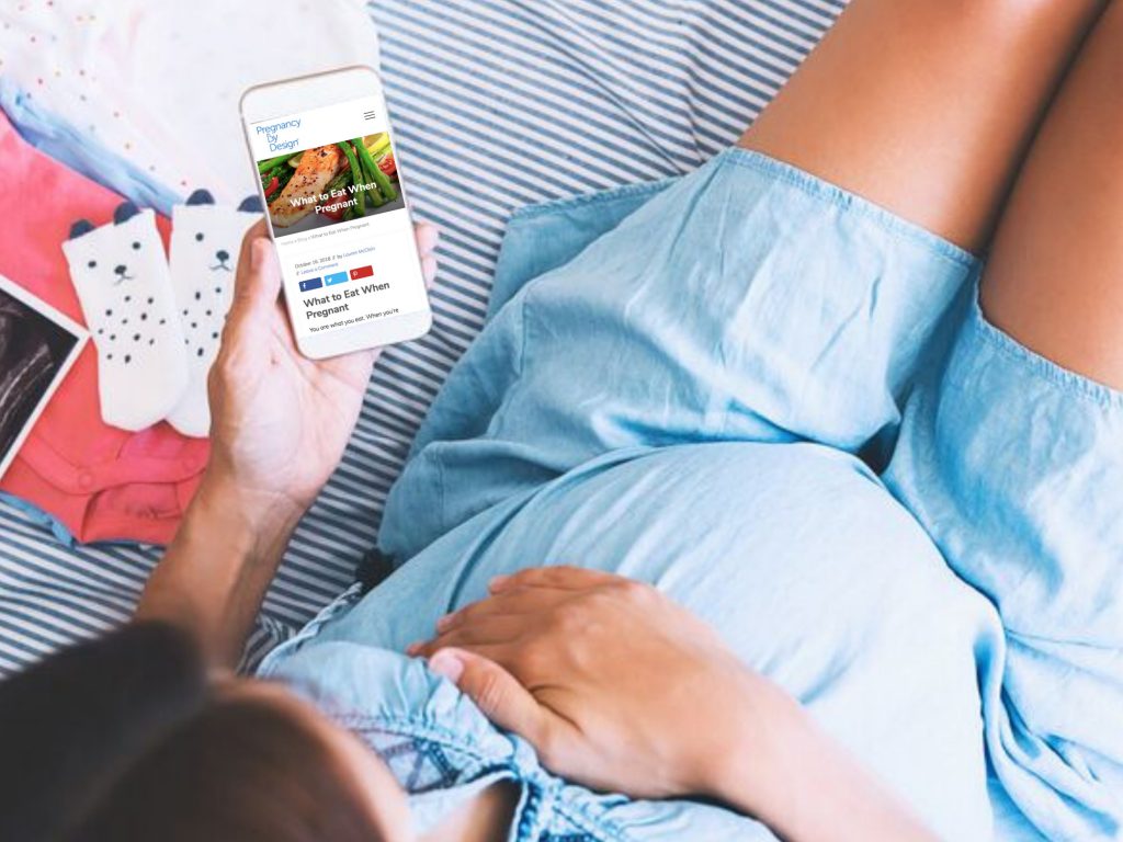 pregnant woman using pregnancy app on her phone
