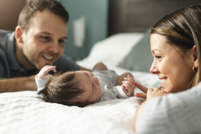 couple-with-newborn-Baby-on-bed