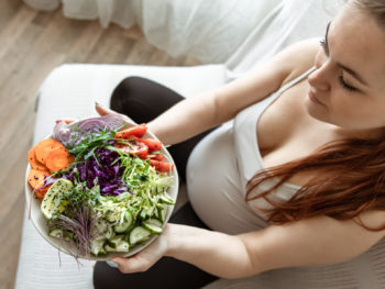 pregnant-woman-eating-plate-of-vegetables-for-a-healthy-microbiome