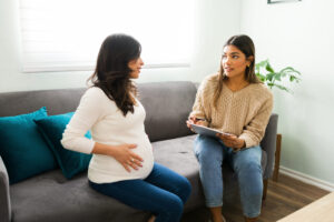 Doula sitting on a couch with a pregnant woman