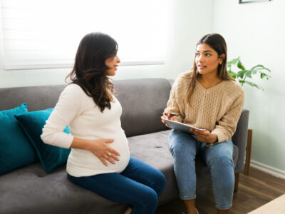 Doula sitting on a couch with a pregnant woman