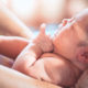 cute-asian-newborn-being-held-by-parent-in-water